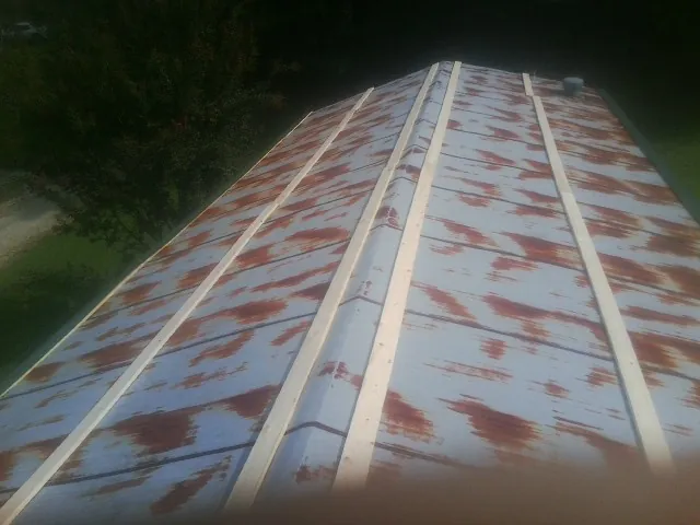 Rusted metal roof panels with new wood purlins before replacement — Storm Damage Roof Repair in Maidsville by Roofing Brothers