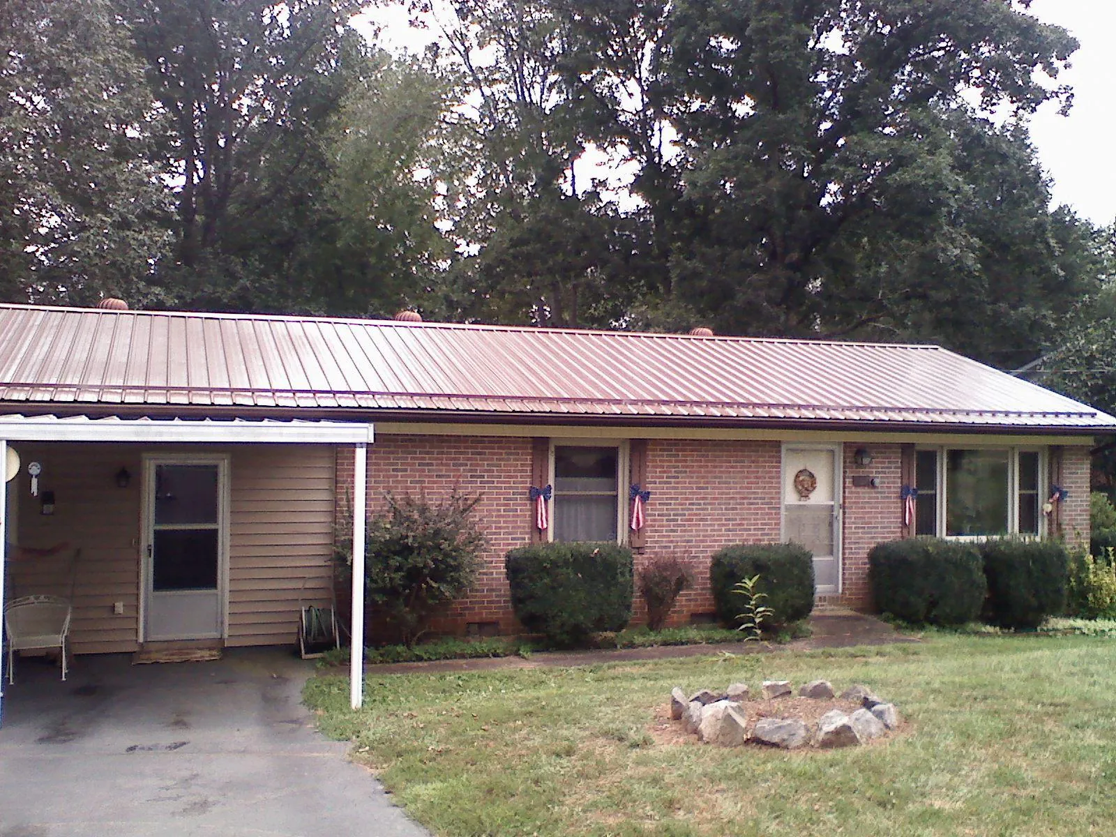 Bronze metal roof and carport on a brick ranch home — Roof Repair work by our crew in Maidsville
